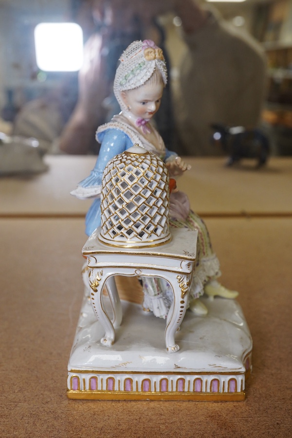 A late 19th century Meissen porcelain figure, ‘Sentiment’ modelled as a young woman seated with a parrot in a gilded cage, 15cm high. Condition - fair, chipping